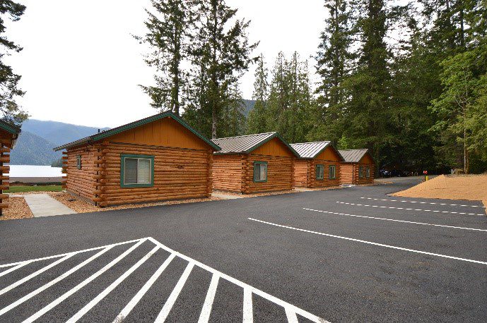 A row of log cabins sitting in the middle of a parking lot.