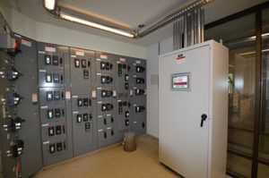 A room with many electrical boxes and a large cabinet.