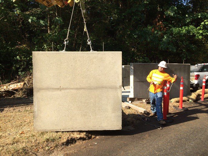 A man standing next to a large concrete block.