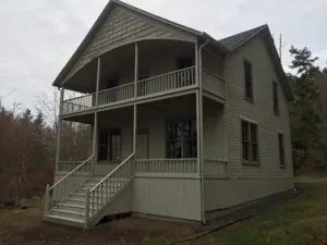 A large two story house with stairs leading to the front.