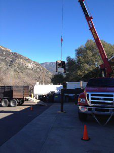 A crane is being used to lift a traffic light.