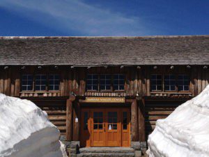 A large wooden building with snow on the roof.
